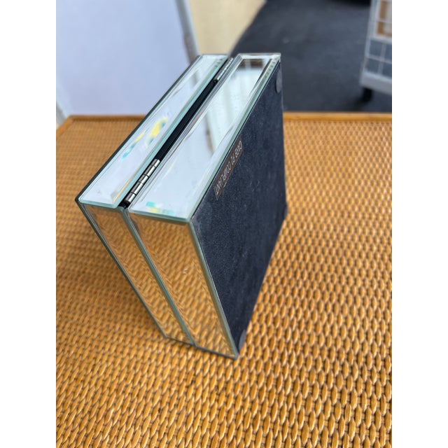 The box features a hinged lid and is constructed with beveled glass panels having a shiny, reflective finish. Its compact...