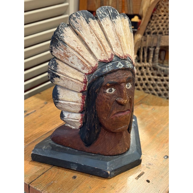 Wonderful early folk art carved wooden bust depicting a Native chief wearing a traditional feathered headdress with aged...