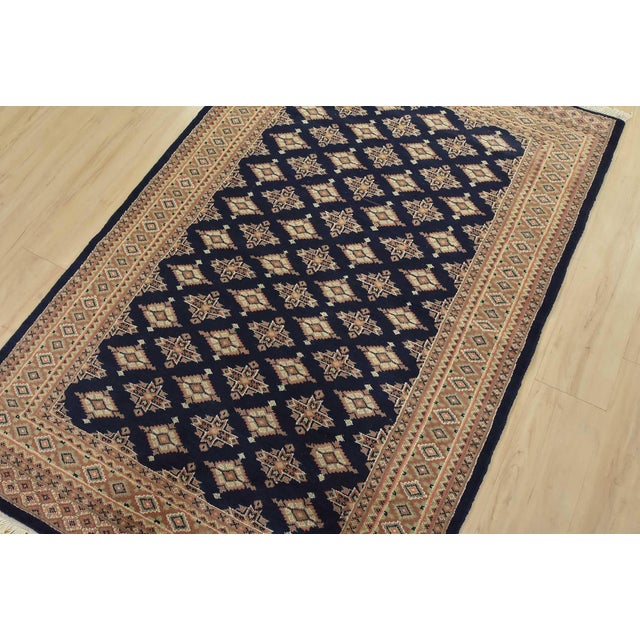 A tribal Bokhara Jaldar rug hand-knotted with fine wool on a cotton foundation. This rug features rows of repeating...