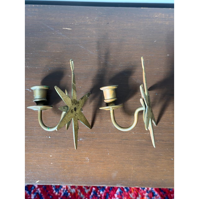 Pair of vintage cast brass multi-point starburst wall sconces, each with a single candle cup, drip pan, and teardrop...