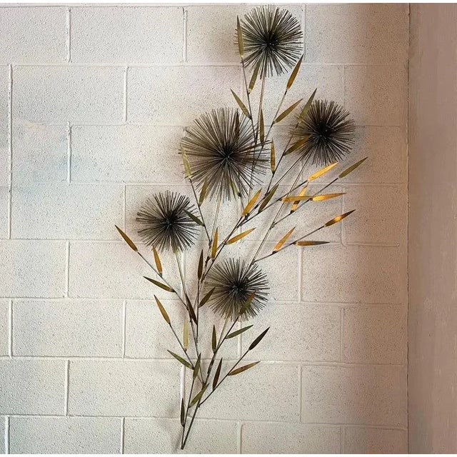 Large, midcentury modern, floral motif, brass wall mounted sculpture by Curtis Jeré features five cascading pom-pom...