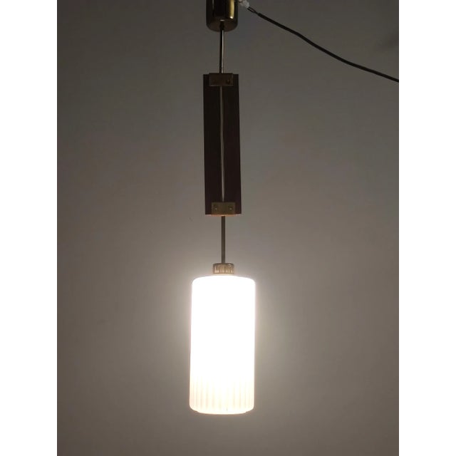 Made in Italy, 1960s. This pendant is made in glazed opaline glass, teak and brass. It is a vintage item, therefore it...