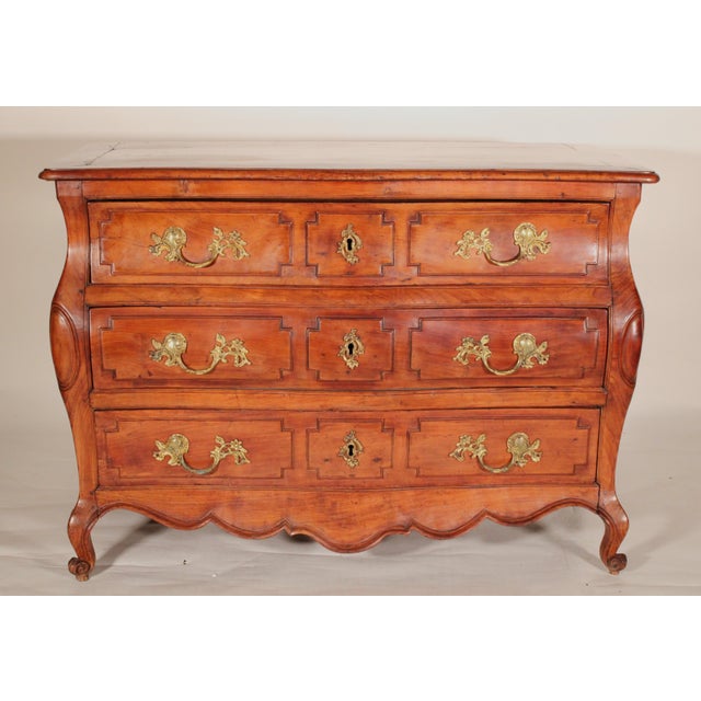 Louis XV provincial fruitwood bombe chest of drawers, 18th century. The top with an inset walnut panel bordered by...