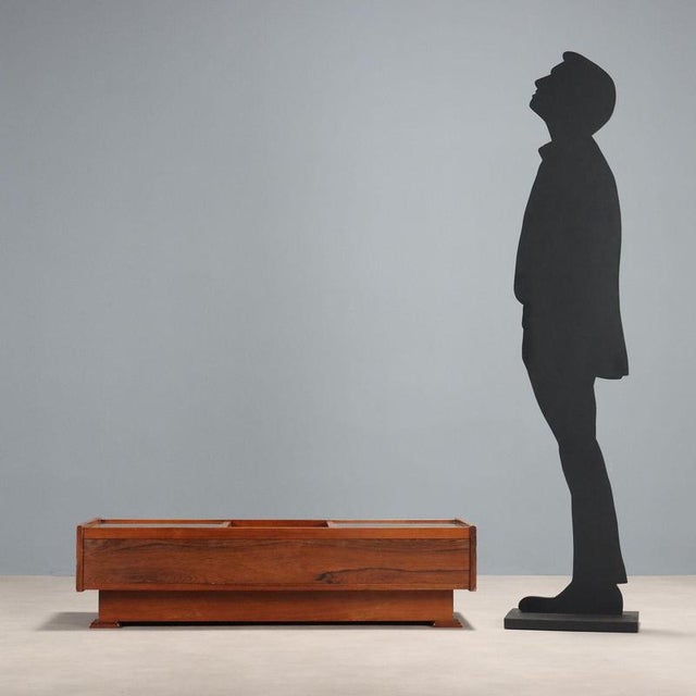 Coffee table with small glass display cases, exotic wood veneer. This piece is attributed to the mentioned designer/maker....