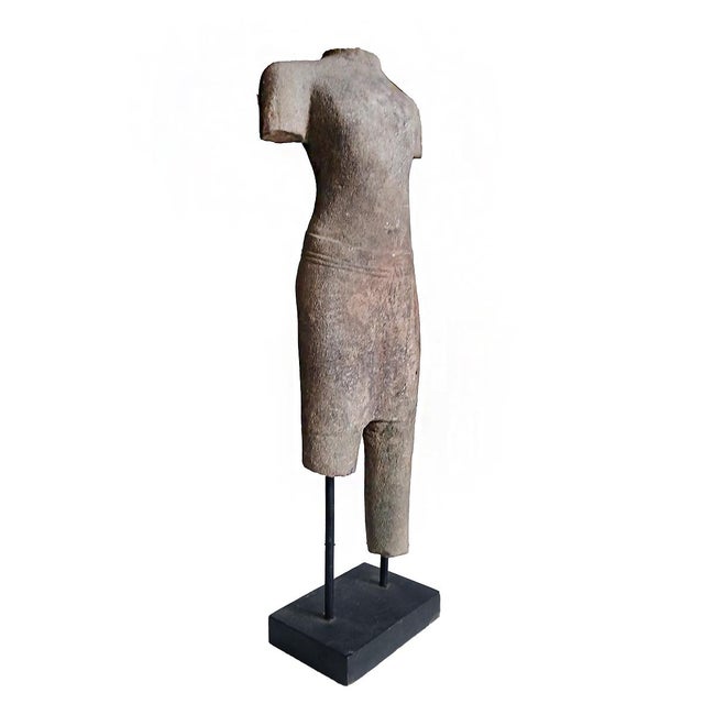 A reclaimed sculpture of a male torso in traditional Khmer attire, from a Eastern Thai temple garden, circa 1930, possibly...