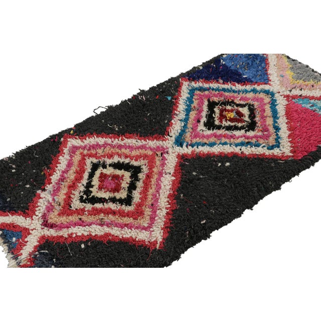 Hand-knotted in wool and fabric circa 1950-1960, this vintage 2x6 Moroccan Boucherouite rug is believed to hail from the...