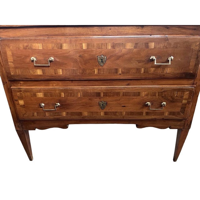 Neoclassical commode hand-made in Italy in the early 1800s using walnut and decorated with walnut cross-banded veneer. The...