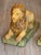 A fine pair of large faience lions, each modeled recumbent on a rectangular base glazed in mottled green. The lions are...