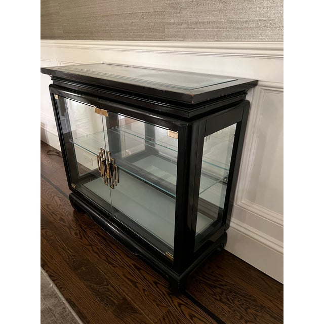 Asian Chinoiserie Pagoda Style Black Glossy Wood Cabinet with glass sides, top, doors and one glass shelf. There is a...