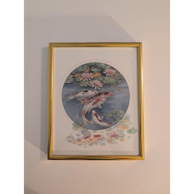 This piece is a signed, limited-edition art print by artist John Cheng, featuring koi fish swimming among blooming water...