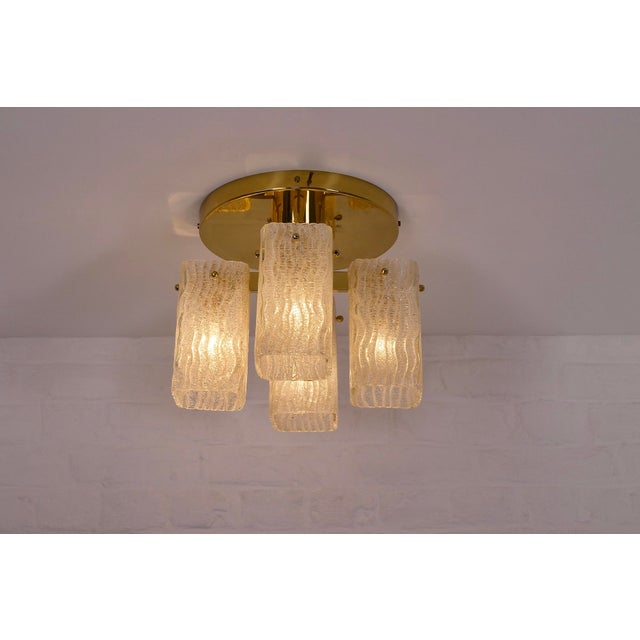 Round-based ceiling light in solid brass, fitted with four thick, deeply textured, translucent glass globes. the quality...
