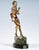 A petite young dancer with her hair tied in a knot at the nape of her neck, wearing a short, tight-fitting dress with a...
