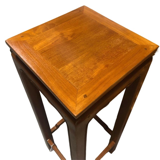 Elevated on graceful square-section legs with refined indented edges above the arched base stretchers, concluding with...