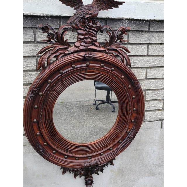 Beautiful 1940s American Federal-style wall mirror featuring an exceptional hand-carved eagle crest and rich mahogany...