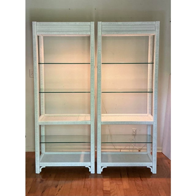 A pair of white washed wicker Etageres with light by Henry Link from the 1970s. These feature three 1/4" polished edge...