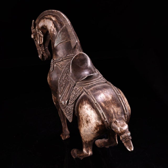 A fine solid-copper figurine of a galloping horse, finished with silvered (鎏银) accents and a handsome aged patina. The...