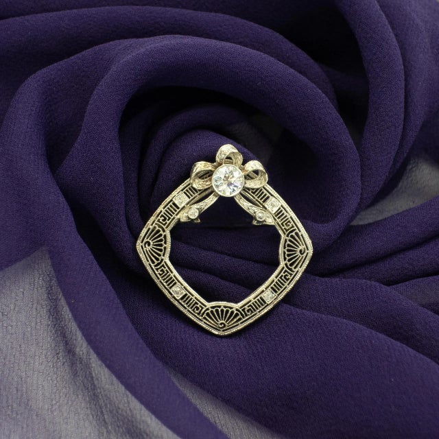 1920s Diamond Filigree Brooch Beautiful & delicate 14K white gold filigree wreath with a ribbon bow on top 7 diamonds on...