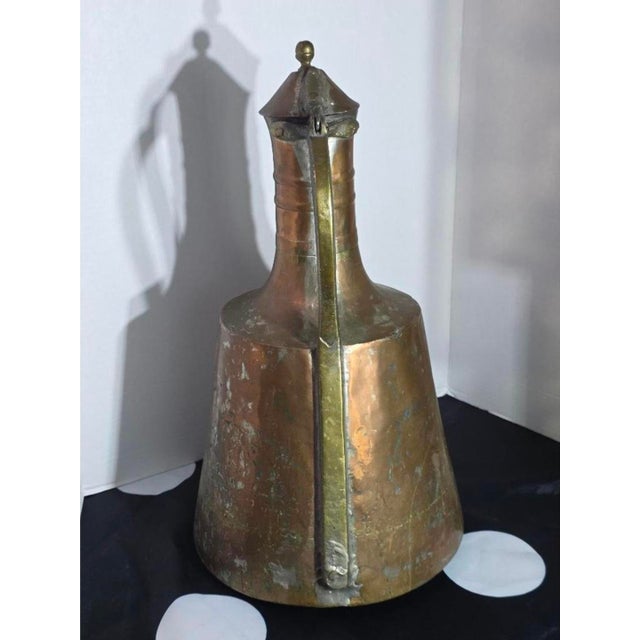 Bring a touch of global history to your home decor with this striking, large vintage hand-hammered copper pitcher....
