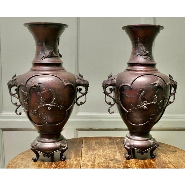 A Pair of Large Japanese Bronze Vases, Meiji Period. These large bronze vases have flared rims at the top with a raised...