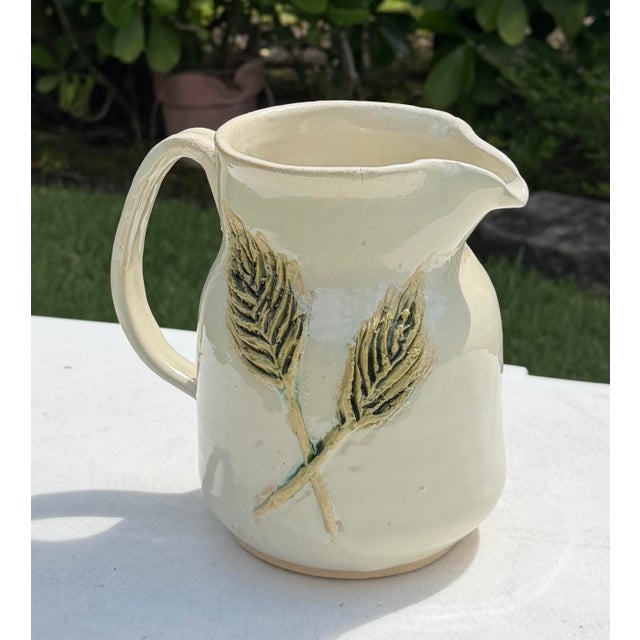 Pretty vintage ceramic pitcher dating to 1994, featuring a softly sculptural form with an organically shaped handle and...