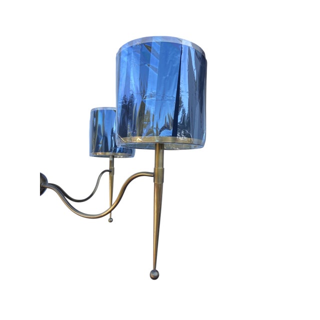 This 4-light chandelier was inspired by mid-century designs. The brass finish on the metal takes on added sophistication...