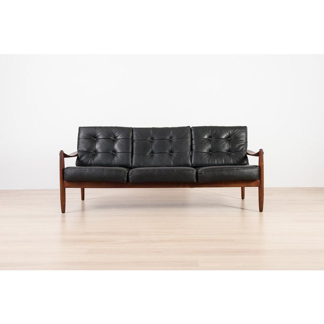 Exceptional Scandinavian three-seat sofa from the 1960s, crafted from solid wood and upholstered in original black...