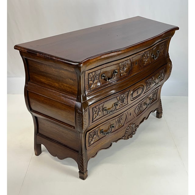 Crafted with a dramatic serpentine front and deeply bowed "bombé" sides, this French Provincial style bombé chest of...
