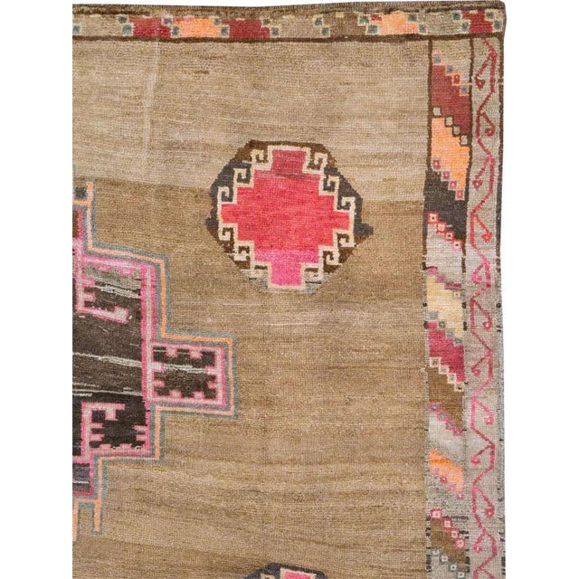 This Mid-20th century Turkish Anatolian room-size carpet presents a bold, graphic composition arranged across a warm...