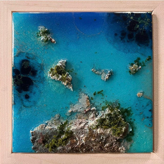 This artwork presents an aerial view of an ocean landscape, where vibrant shades of blue intermingle with textured...