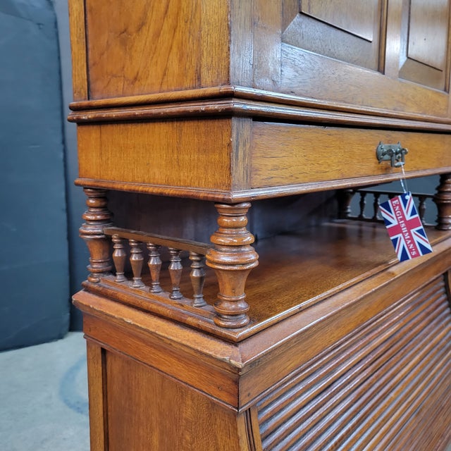 This Charming oak Arts & Crafts bureau cabinet/student desk is in the style of James Shoolbred & Co. The galleried shaped...