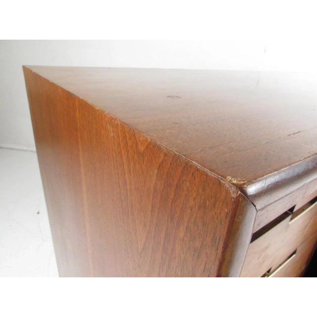 This attractive vintage modern walnut credenza features nine hefty drawers hidden by unique sliding doors. Sleek design...