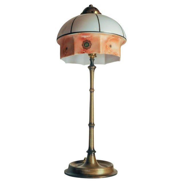 An Art Nouveau Art Deco brass faux bamboo table lamp featuring a stained glass style shade. This antique lamp features a...