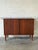 This compact storage piece features smooth sliding doors and sleek tapered legs. The refined silhouette highlights the...