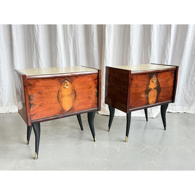 Charming mid century pair of wooden bedside tables with brass details and glass top, Italy, 1950s. A piece which shows...