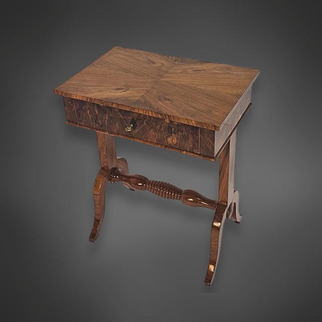 Biedermeier side table with a turned crossbar. The case is veneered in walnut, and the top features a four-fold mirrored...