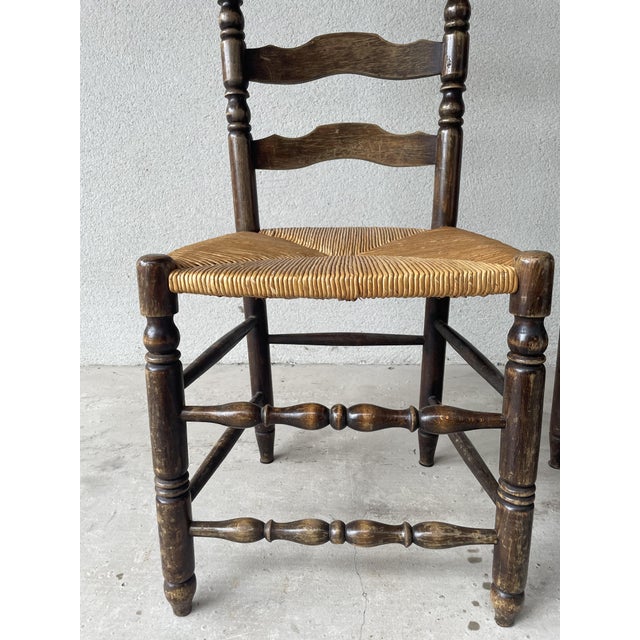 Pair of turned solid oak ladder chairs with straw seats. 1950s, with handcrafted charm. Note the beautiful woodwork,...