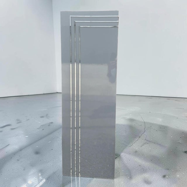 Stylish postmodern winter grey laminate pedestal with chrome striping, giving it a touch of mid-century modern feel....