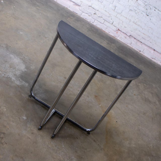 Handsome vintage Art Deco Streamline Moderne demilune side table composed of a chrome tube frame w/a time faded black...