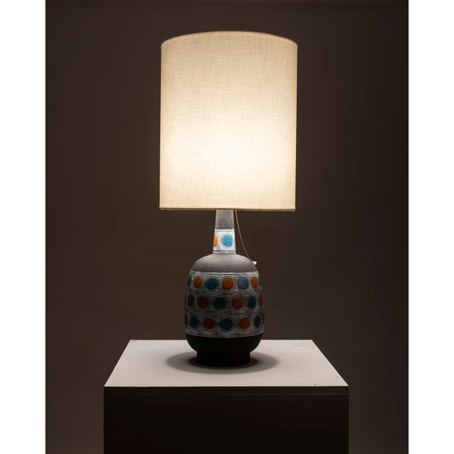 A table lamp representative of European design from the 1960s and 70s, crafted from glazed ceramic with a matte black...