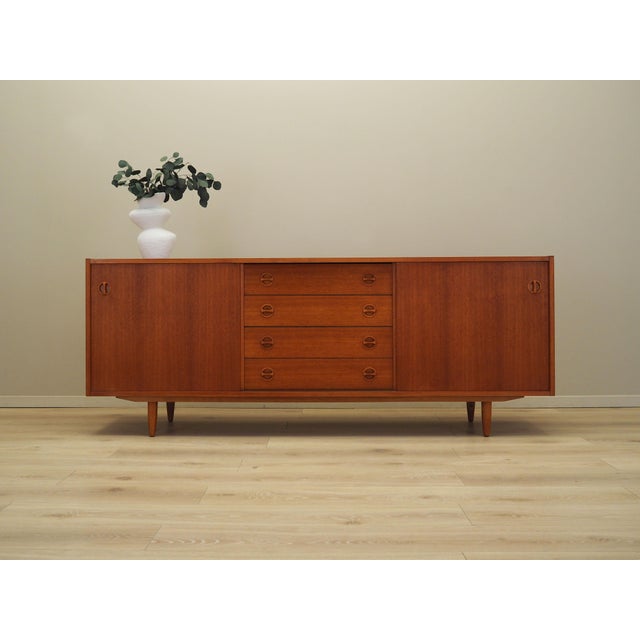 The sideboard was made in the 1970s, Danish production. The structure is covered with teak veneer. The legs are made of...
