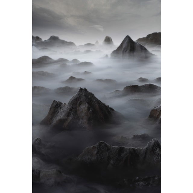This artwork presents a surreal landscape, where sculpted peaks emerge from a misty, ethereal environment, created through...