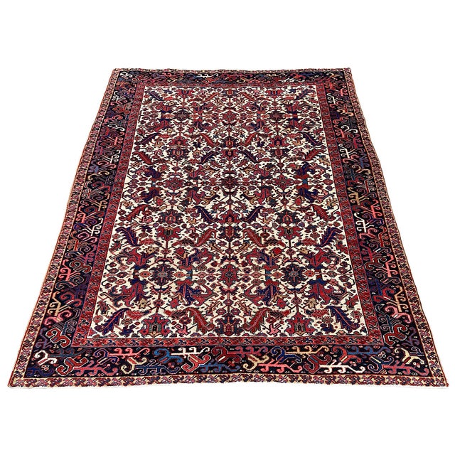 A wonderful antique Heriz rug, hand woven circa 1920 with an all over geometrical design on an unusual ivory field and...