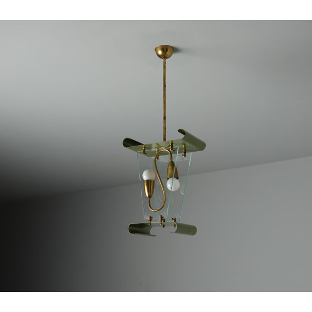 This Italian pendant lamp from the 1950s features a distinctive design with a structural composition that includes folded...