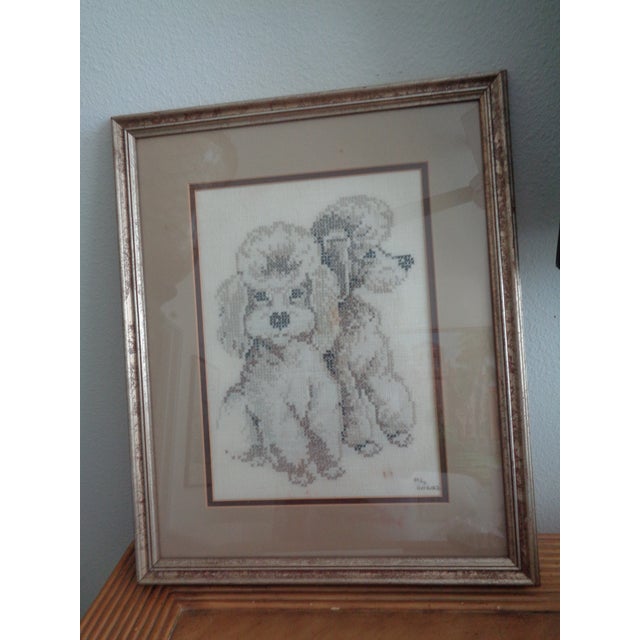 Vintage cross stich poodles on linen in a neutral color. Signed and dated 1986. Lovely frame with glass and ready to hang..