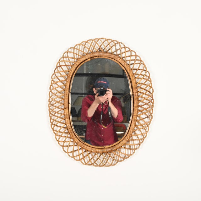 Stunning large oval mirror in French Riviera style, crafted from hand-woven wicker, curved rattan, and bamboo. This...