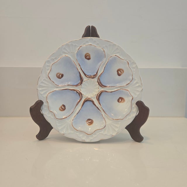 An antique European porcelain 6-well oyster plate featuring a white background with a soft lavender-blue gradient glaze...