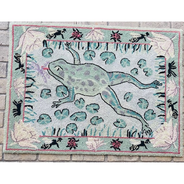 Whimsical late 20th century hooked wool folk art tapestry or rug featuring a leaping frog among lily pads trying to catch...
