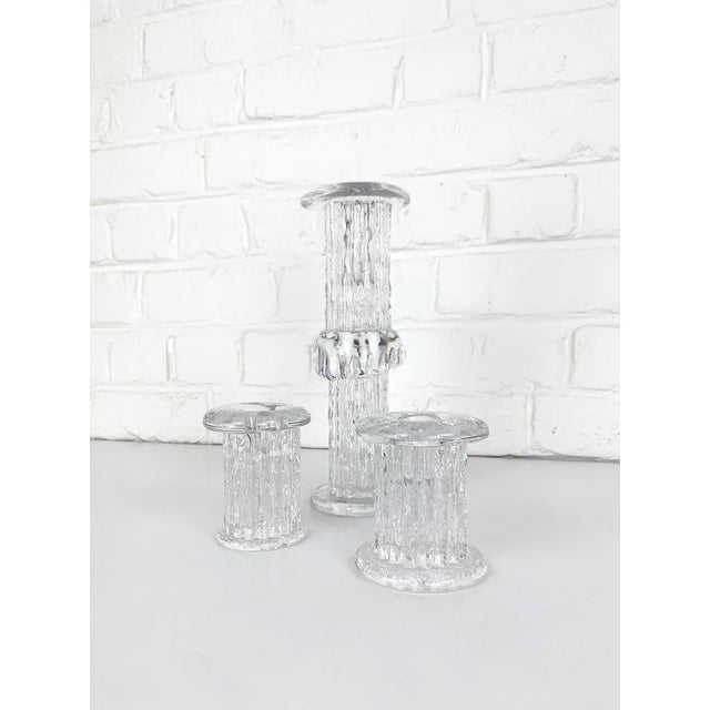 Crystal glass candle holders, design by Göran Warff for Kosta Boda, Sweden in the 1970s. Set of 3. One of the candlesticks...
