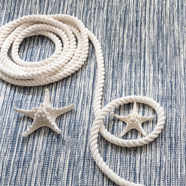 Navy and white threads with a blanket stitch-like overlay evoke the incoming tidal waters as they dash and crash to the...