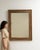 Carved giltwood mirror in Antique Gold. Its antique gold finish sets off repeating foliate relief carving around the...